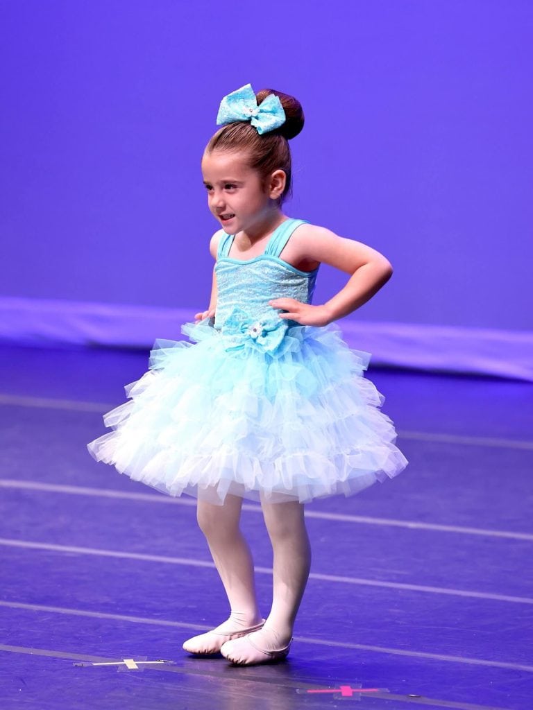 Young ballet dancer on stage in blue costume